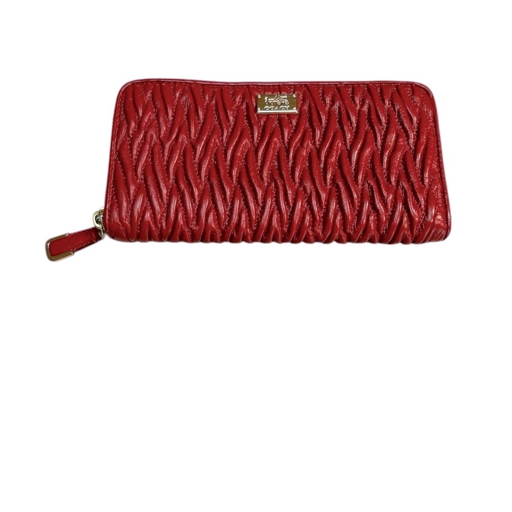 Coach Madison twisted leather zip around wallet in a burgundy red color.